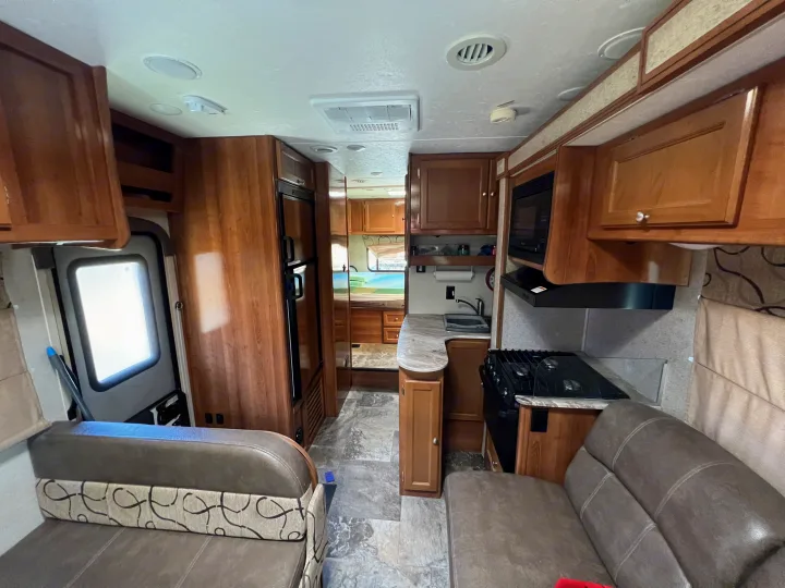 Spacious rv rental interior: full kitchen, seating area, and rear bedroom visible. Perfect for your next road trip.. Coachmen Leprechaun 2019