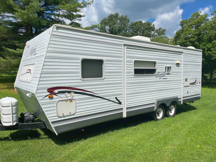 A light gray Jayco Eagle RV travel trailer, with maroon and black graphics, is parked on green grass. Ideal for rv rental.. Jayco Eagle 2003