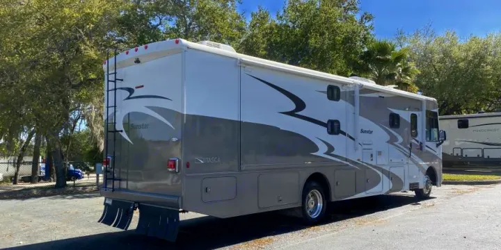 Sunstar Itasca RV rental: A large white and gray motorhome parked outdoors on a sunny day, ready for adventure.. Itasca Sunstar 2013