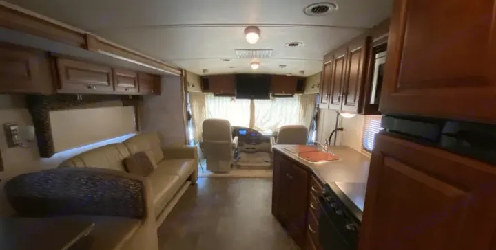 Explore this spacious RV rental motorhome interior: A well-lit living area, full kitchen, and front cockpit await.. Itasca Sunstar 2013