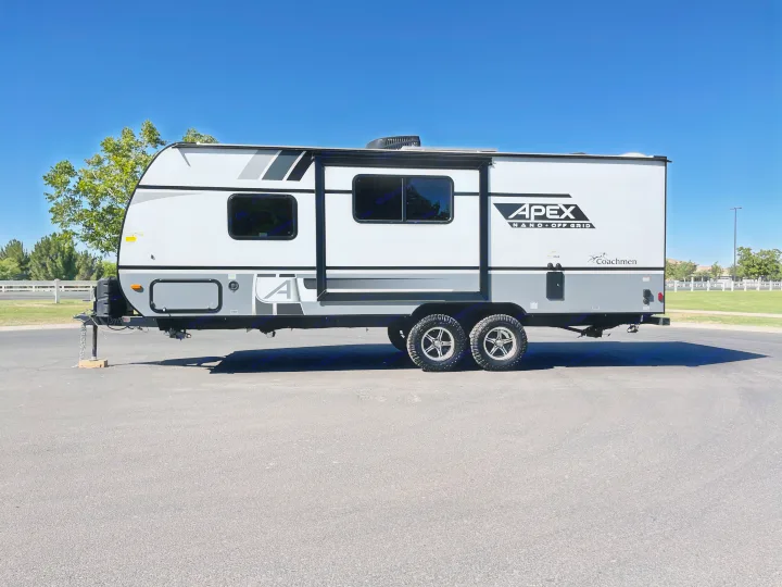 A sleek white and gray Coachmen Apex Nano off-grid travel trailer, perfect for an RV rental and outdoor adventure.. Coachmen Apex 2022