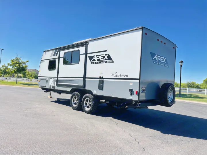 Gray Coachmen Apex travel trailer RV rental, parked on asphalt, ready for adventure.. Coachmen Apex 2022