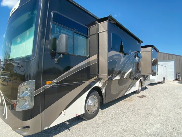 Sleek black and gray RV, a perfect option for your next rv rental adventure. Parked on a gravel lot.. Coachmen Sports Coach 339DS 2019
