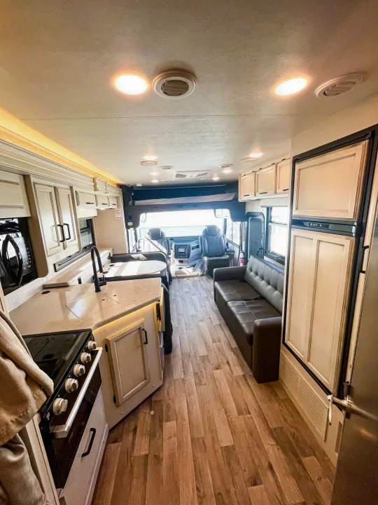 A bright, modern rv rental interior featuring a full kitchen, comfortable living area, and cockpit for travel.. Jayco Alante 29F 2023