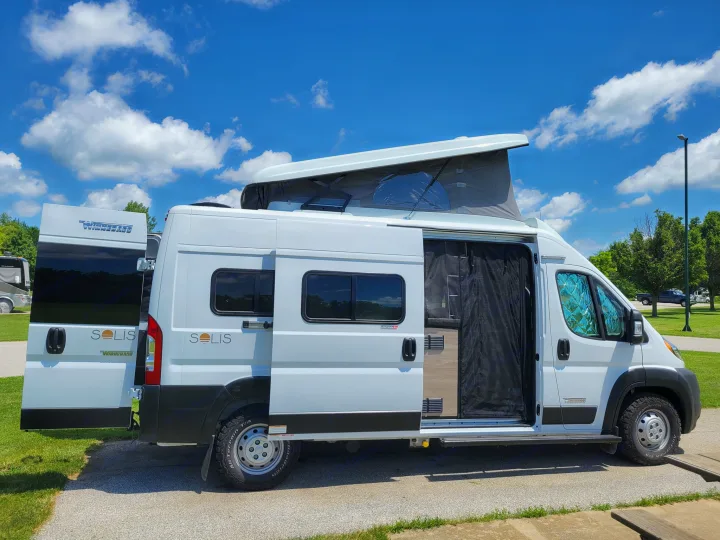 Bright white Winnebago Solis pop-top camper van with doors open, ready for your next RV rental adventure.. Winnebago Solis 2022