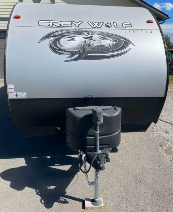 Grey Wolf Limited RV rental ready for adventure. Front view of this travel trailer with its hitch and propane tanks.. Forest River Cherokee Grey Wolf 2021