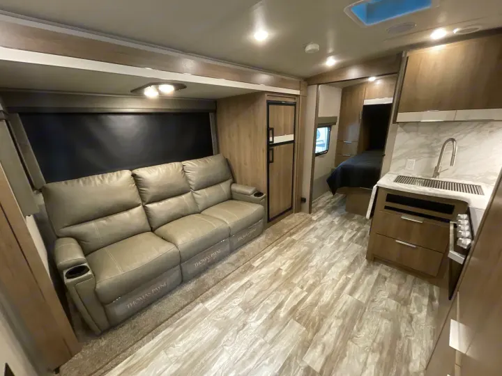 Step inside this cozy RV rental! Features a modern living area with recliners, a compact kitchen, and a comfortable bedroom nook.. Grand Design Imagine 2400BH 2021