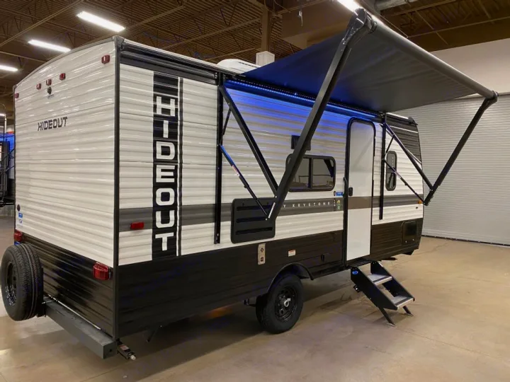 Explore the outdoors! This white & black Hideout travel trailer, ideal for an RV rental, features an extended awning & accessible steps.. Keystone RV Hideout 2022