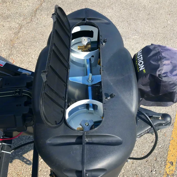 An RV rental's front hitch area with an open cover, revealing two white propane tanks and battery box. Ready for camping.. Crossroads RV Volante 2022