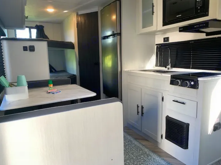 Spacious rv rental interior showcasing a modern kitchen, dinette, and bunk beds for comfortable travel.. Forest River Salem FSX 2022