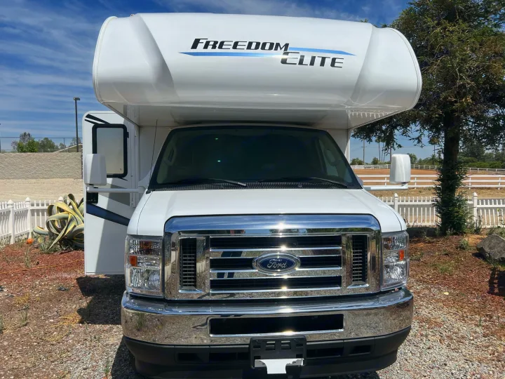 White Freedom Elite Class C RV (Ford chassis) parked outdoors. This motorhome is perfect for your next rv rental adventure.. Thor Freedom Elite 2022