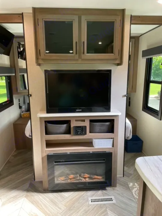 Interior of a modern RV rental, featuring a living area with TV, an electric fireplace, and smart storage.. Highland Ridge RV Olympia 2022