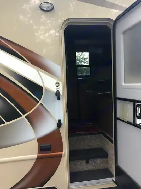 RV rental's open side door shows entry steps and a glimpse inside, ready for your next travel adventure.. Thor Four Winds 2017