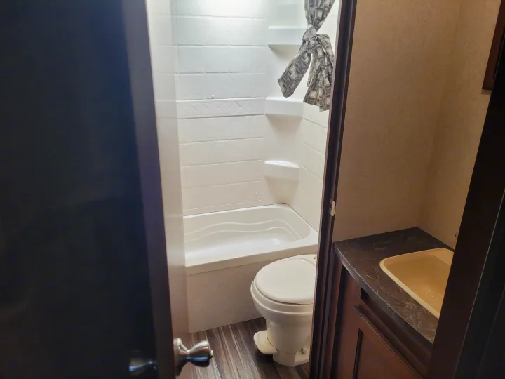 Inside this RV rental: A compact bathroom featuring a white shower/tub, toilet, and a vanity with a sink.. Jayco Jay Flight SLX 2017