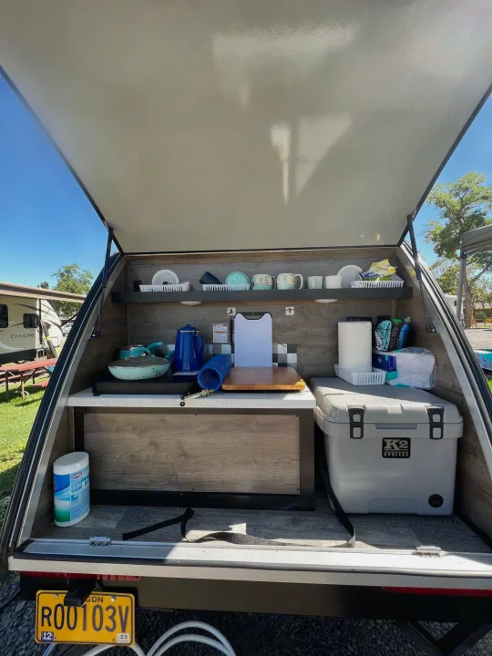 This rv rental's outdoor kitchen is perfect for camping! Features a K2 cooler, cookware, and organized storage shelves.. Braxton Creek Bushwhacker 2021