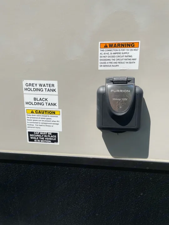 RV rental panel with a 30A power inlet, grey/black water tank labels, and crucial safety/operational warnings.. Starcraft Super Lite 2022