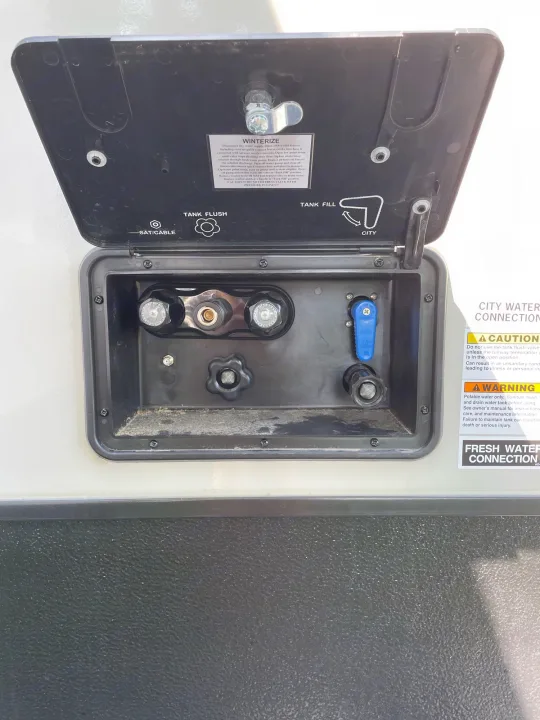 RV rental's open utility panel with water, tank fill/flush, city, SAT/cable connections, & winterize instructions.. Starcraft Super Lite 2022