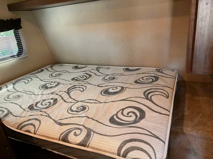 Comfortable RV rental bedroom with a patterned mattress. Perfect for a cozy night's sleep during your next adventure.. Keystone RV Hideout 2019