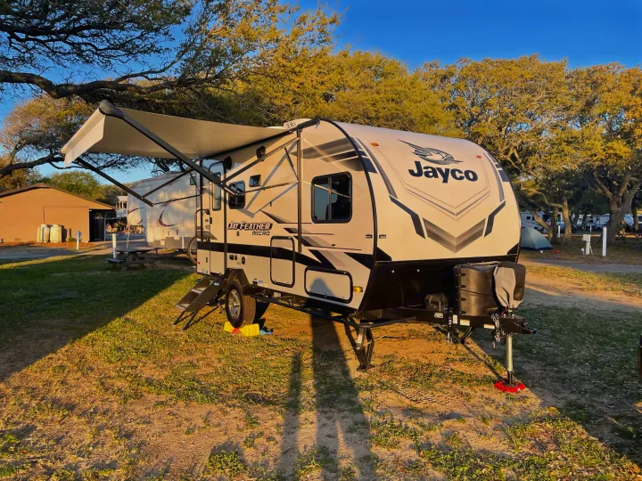 Jayco RV with awning extended at a sunny campsite, perfect for your next rv rental adventure.. Jayco Jay Feather Micro 2022