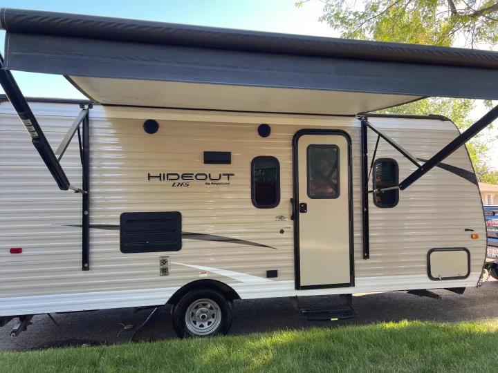Keystone Hideout travel trailer, an RV rental with its awning extended, ready for adventures.. Keystone RV Hideout 2019
