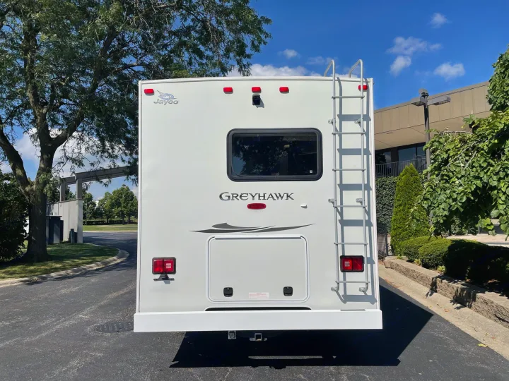Rear view of a white Jayco Greyhawk RV. This rv rental option features a roof ladder, backup camera, and rear window.. Jayco Greyhawk 2013