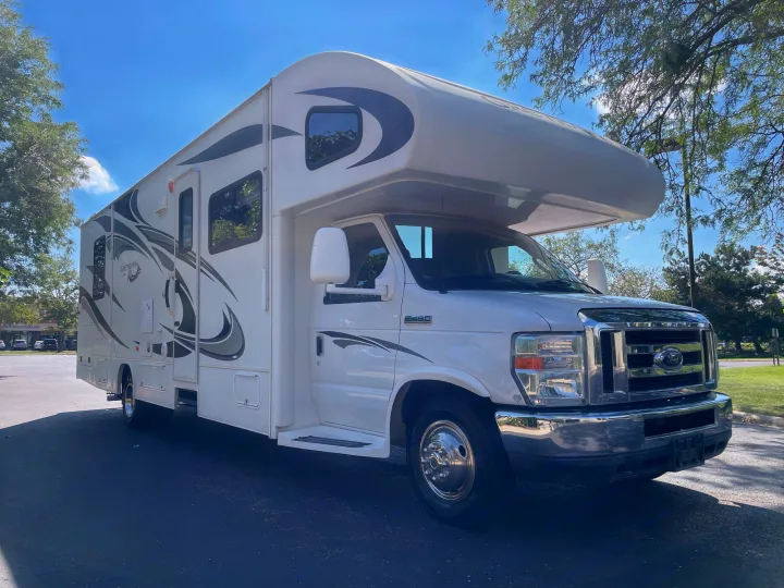 Sunny day highlights a white Greyhawk Class C RV rental, perfect for road trips and outdoor adventures.. Jayco Greyhawk 2013