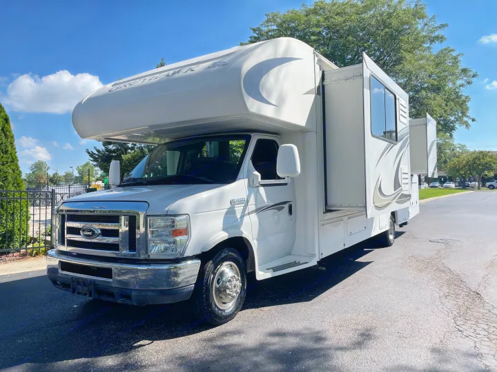 This white Class C Jayco Greyhawk motorhome, ideal for rv rental, is parked outdoors with slide-outs extended.. Jayco Greyhawk 2013
