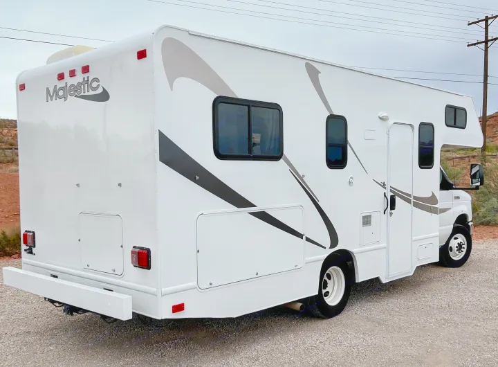 White Majestic RV rental motorhome, seen from the side-rear on gravel.. Thor Majestic 2018