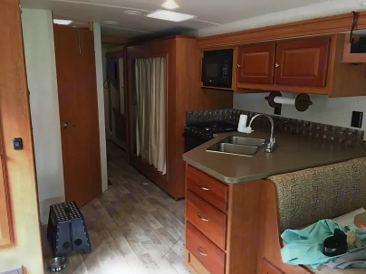 RV rental interior with full kitchen, dinette seating, and wood cabinetry. A comfortable home on wheels.. Winnebago Vista 2017