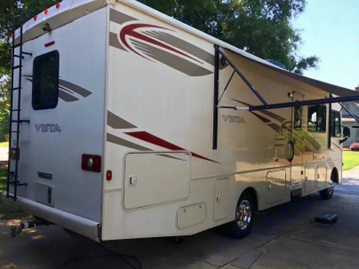 Spacious beige Winnebago Vista motorhome with awning extended, perfect for your next rv rental adventure.. Winnebago Vista 2017