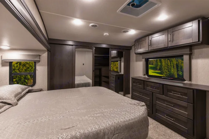 Comfortable RV bedroom interior, perfect for an rv rental. Enjoy ample storage, a large bed, and scenic window views.. Grand Design Reflection 2021