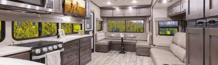 RV rental's roomy interior: a modern kitchen, comfortable U-shaped dinette, and sofa, all with scenic window views.. Grand Design Reflection 2021