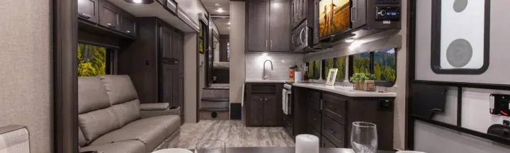 Explore this cozy RV rental interior: a modern kitchen, comfortable living space, and scenic outdoor views from windows.. Grand Design Reflection 2021