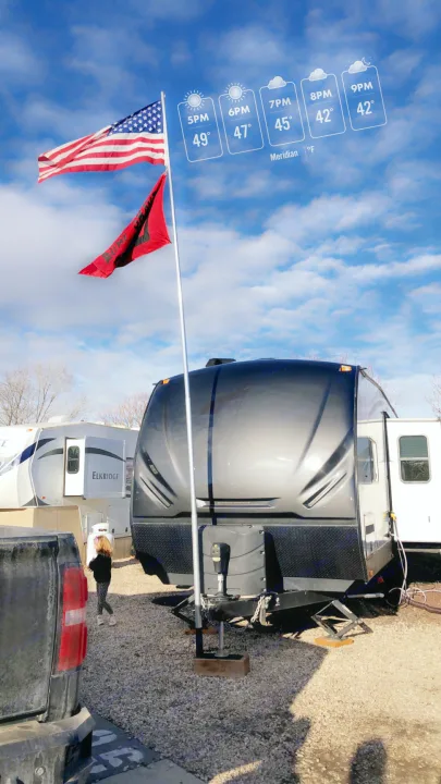 An RV rental parked with an American flag and a red flag on a pole. Weather overlay shows temperatures from 49° to 42°F.. Heartland Torque 2017