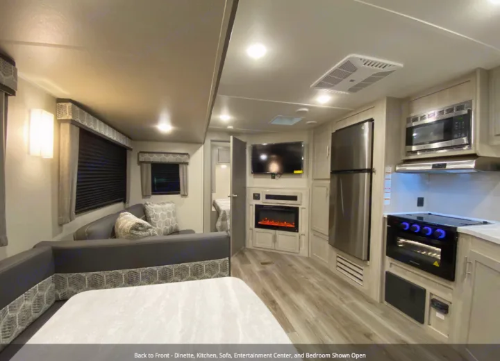 This rv rental features a dinette, sofa, entertainment center with TV/fireplace, kitchen, and an open bedroom.. Forest River Coachmen Catalina Legacy 2022