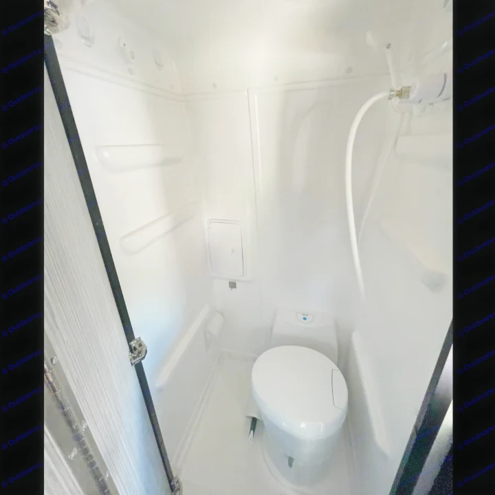 Inside an RV rental: a clean, compact wet bath with a toilet and handheld shower. White walls and floor for easy maintenance.. Winnebago Revel 2021