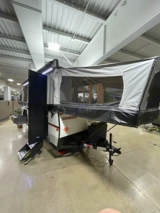 An extended Rockwood pop-up camper, perfect for an RV rental, displayed indoors in a showroom.. Forest River Rockwood Premier 2022