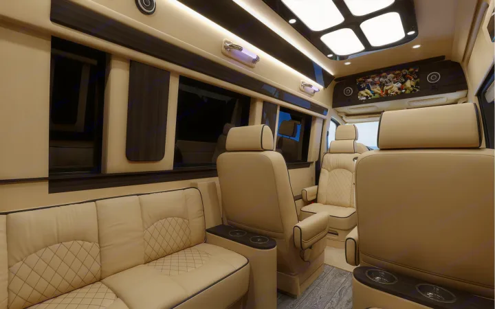 Spacious luxury RV rental interior with cream leather seats, sofa, entertainment, and ambient lighting for premium travel.. Ultimate Toys Ultimate Coach 2023
