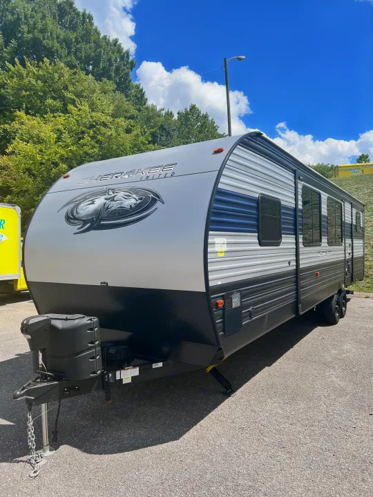 Explore this modern gray & blue Cherokee travel trailer, an ideal rv rental for outdoor adventures, parked under a bright sky.. Forest River Cherokee 2021