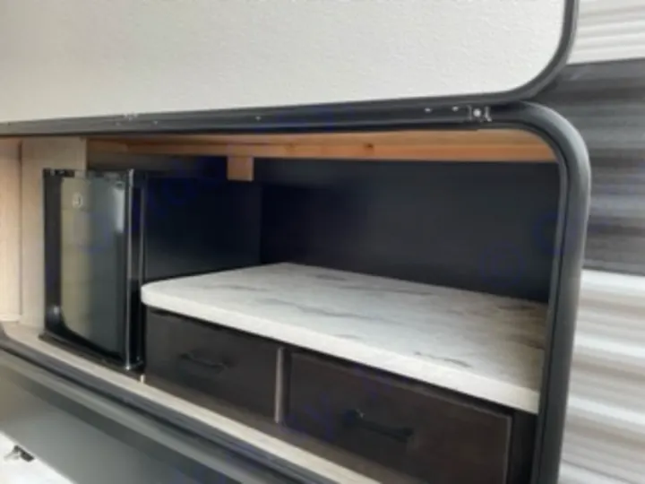 This RV rental's outdoor kitchen boasts a mini-fridge, counter, and drawers, perfect for camping convenience.. Jayco Jay Flight SLX 8 2023