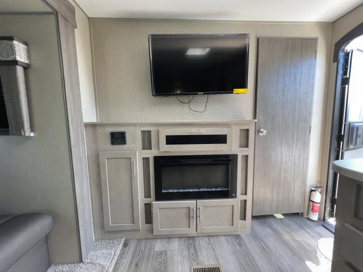 RV rental interior: Enjoy the entertainment unit with TV, electric fireplace, and storage cabinets for your travels.. Coachmen Catalina 2022
