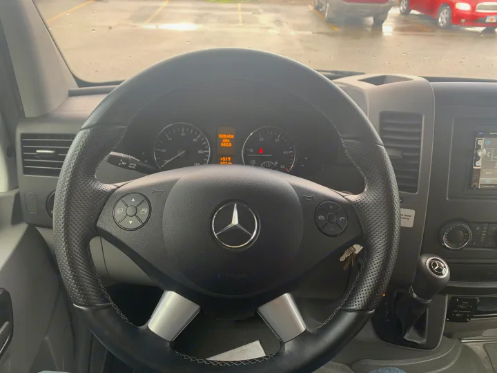Driver's view inside a Mercedes-Benz rv rental, showing the steering wheel, dashboard with 28,408 miles, and 51°F temp.. Thor Motor Coach Chateau Sprinter 2018