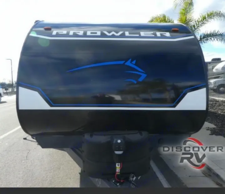 Discover RV rental: Front view of a black Prowler travel trailer with blue horse graphic and white trim, ready for adventure.. Heartland Prowler 2022