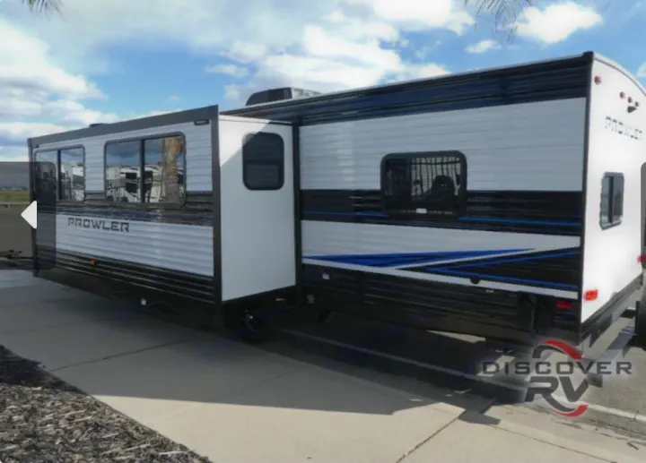 White Prowler travel trailer with blue/black stripes, ideal for an RV rental adventure, shown with its slide-out extended.. Heartland Prowler 2022