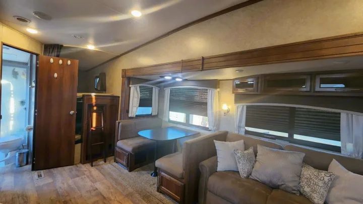 Spacious RV rental interior: living area with sofa, booth dinette, plus bathroom and bunk beds.. Jayco Eagle HT 2018