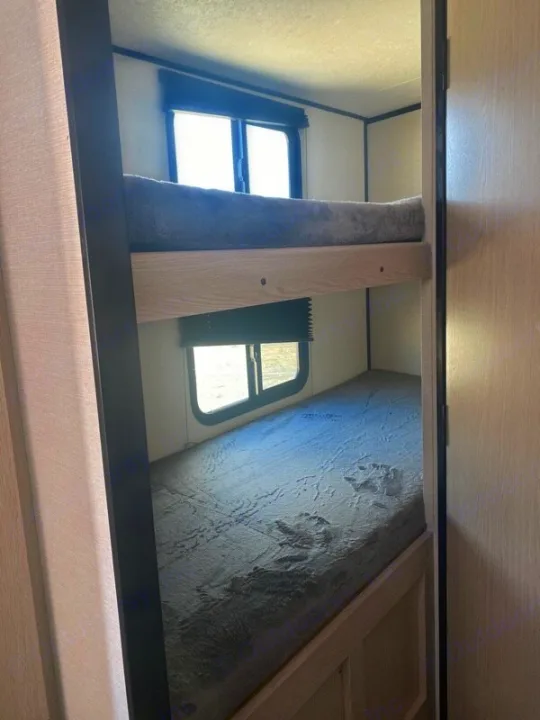 RV rental interior: Two bunk beds with mattresses & windows. Provides compact sleeping for campers.. Forest River Coachman Apex Nano 2022