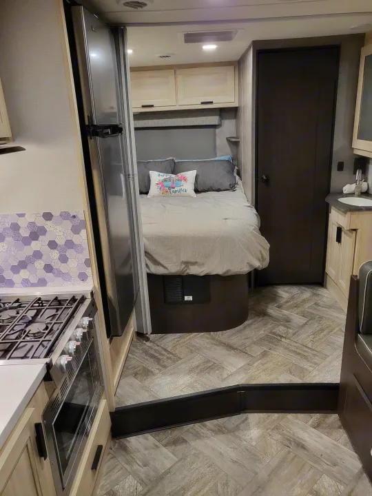 Spacious RV rental interior featuring kitchen, cozy bedroom, bathroom vanity, and stylish flooring.. Forest River Sunseeker LE 2022