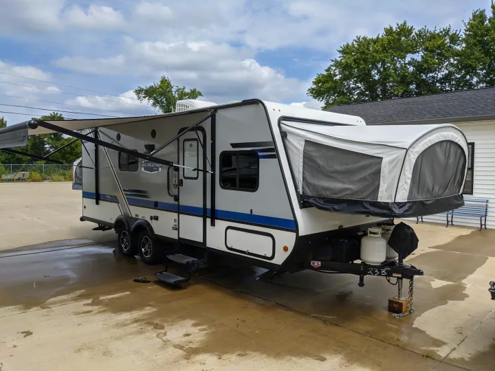 Modern white/gray hybrid RV with extended awning and pop-out bed, ready for your rv rental adventure.. Jayco Jay Feather 2019