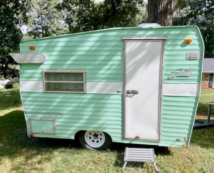 Discover this charming mint green vintage travel trailer, ideal for your next RV rental adventure. Retro camper fun!. Shasta Compact 1973