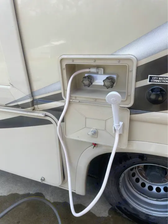An RV rental's outdoor shower with hot/cold taps and hose, ideal for rinsing off at the campsite or during travel.. Thor Motor Coach Chateau Sprinter 2018